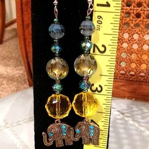 Long pretty earrings with crystals that are bluish green and yellow and Elephant